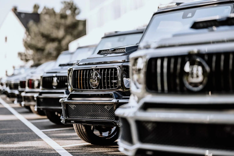 Row of luxury SUVs parked in a row with a blurred background