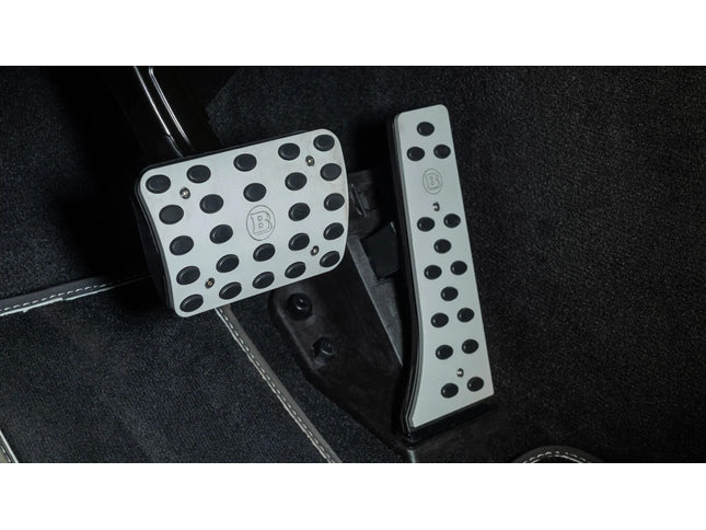 Car pedals with branded踏板 on a black floor mat