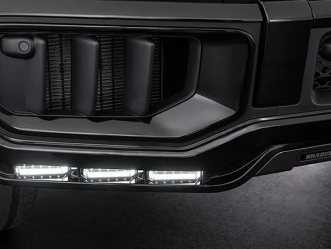 Close-up of a vehicle's front grille with LED lights on a dark background