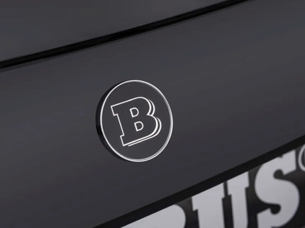 Close-up of a logo on a black surface with 'B' lettering.
