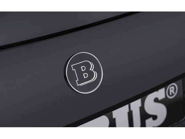Close-up of a logo on a black surface with 'B' lettering.