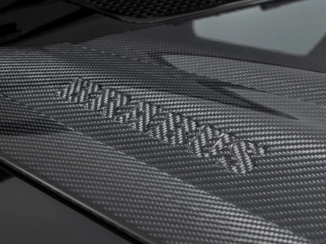 Carbon fiber texture with a brand logo on a dark background