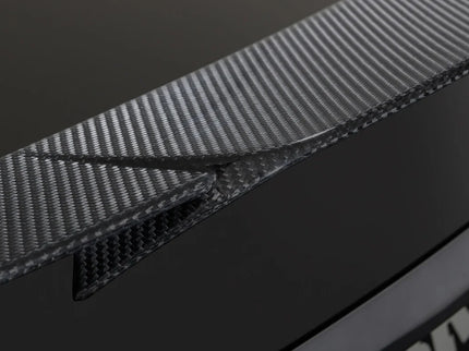 Close-up of a car's carbon fiber trim and badge