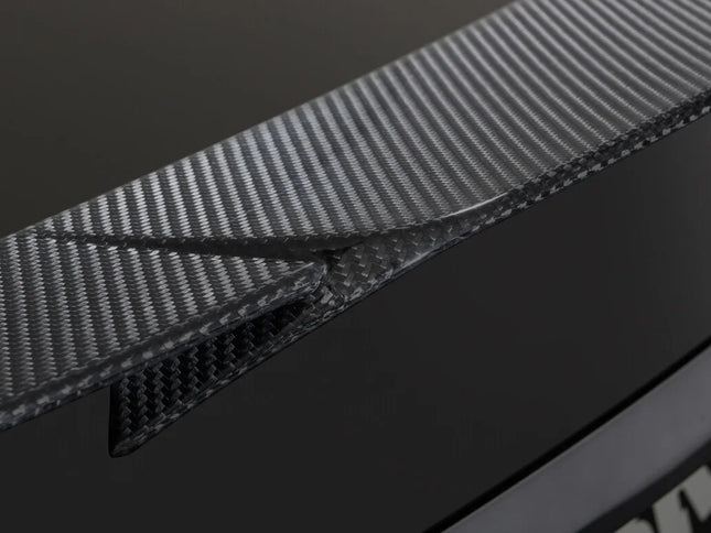 Close-up of a car's carbon fiber trim and badge