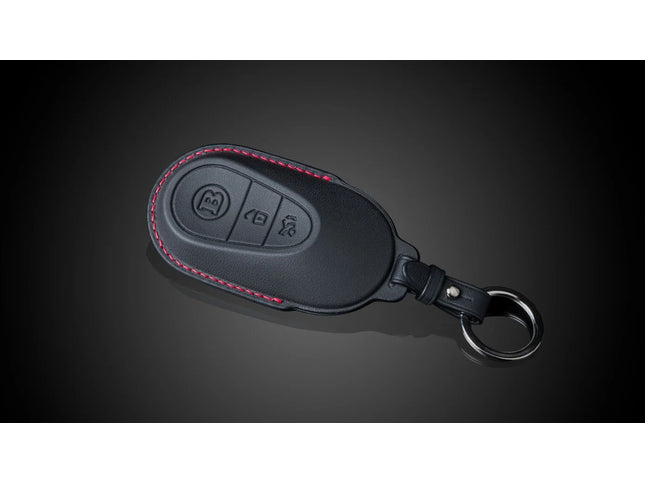 Black leather key fob cover with button symbols on a dark background